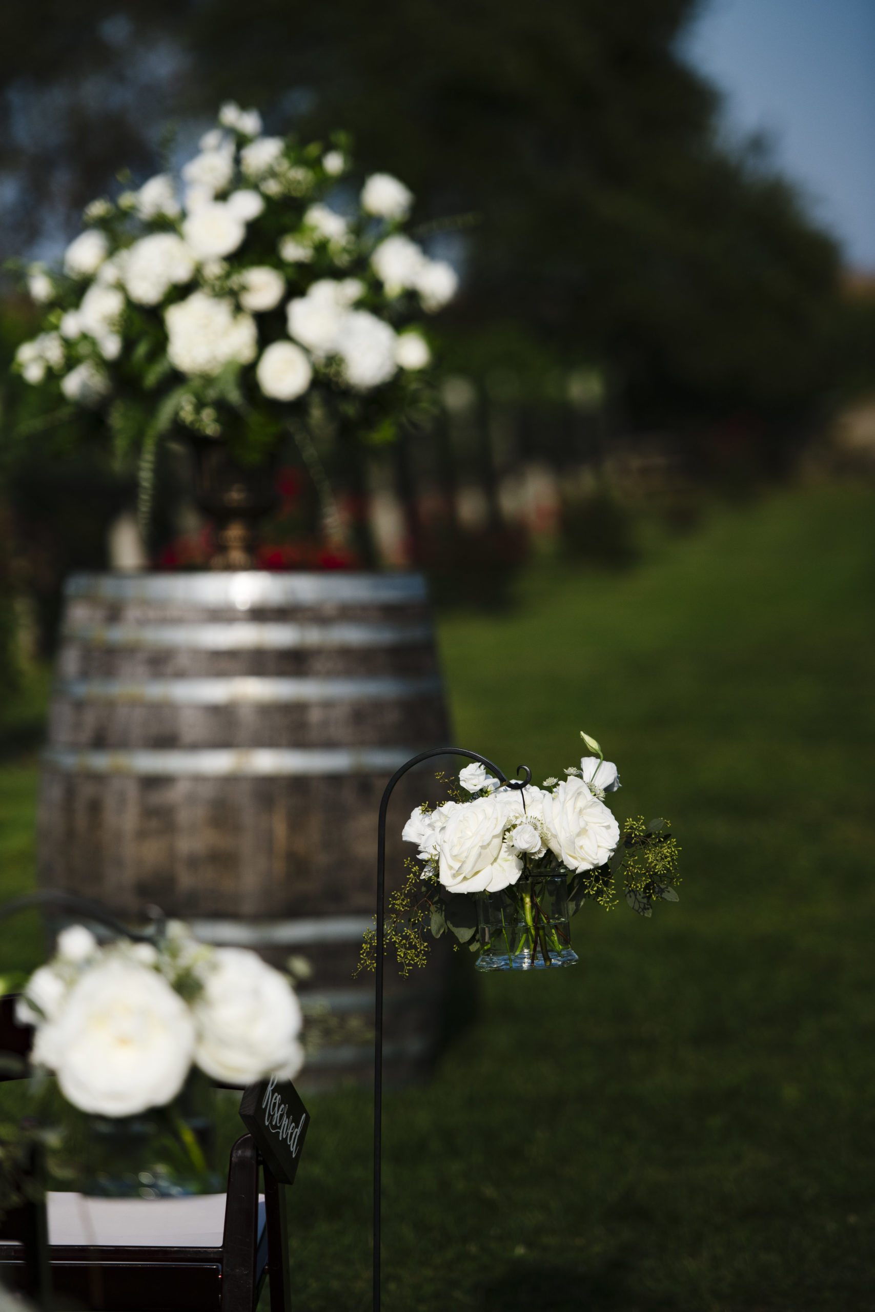 Blue, white and green florals on a wine barrel for the ceremony at Jonathan Edwards Winery in Connecticut - Pearl Weddings &amp; Events