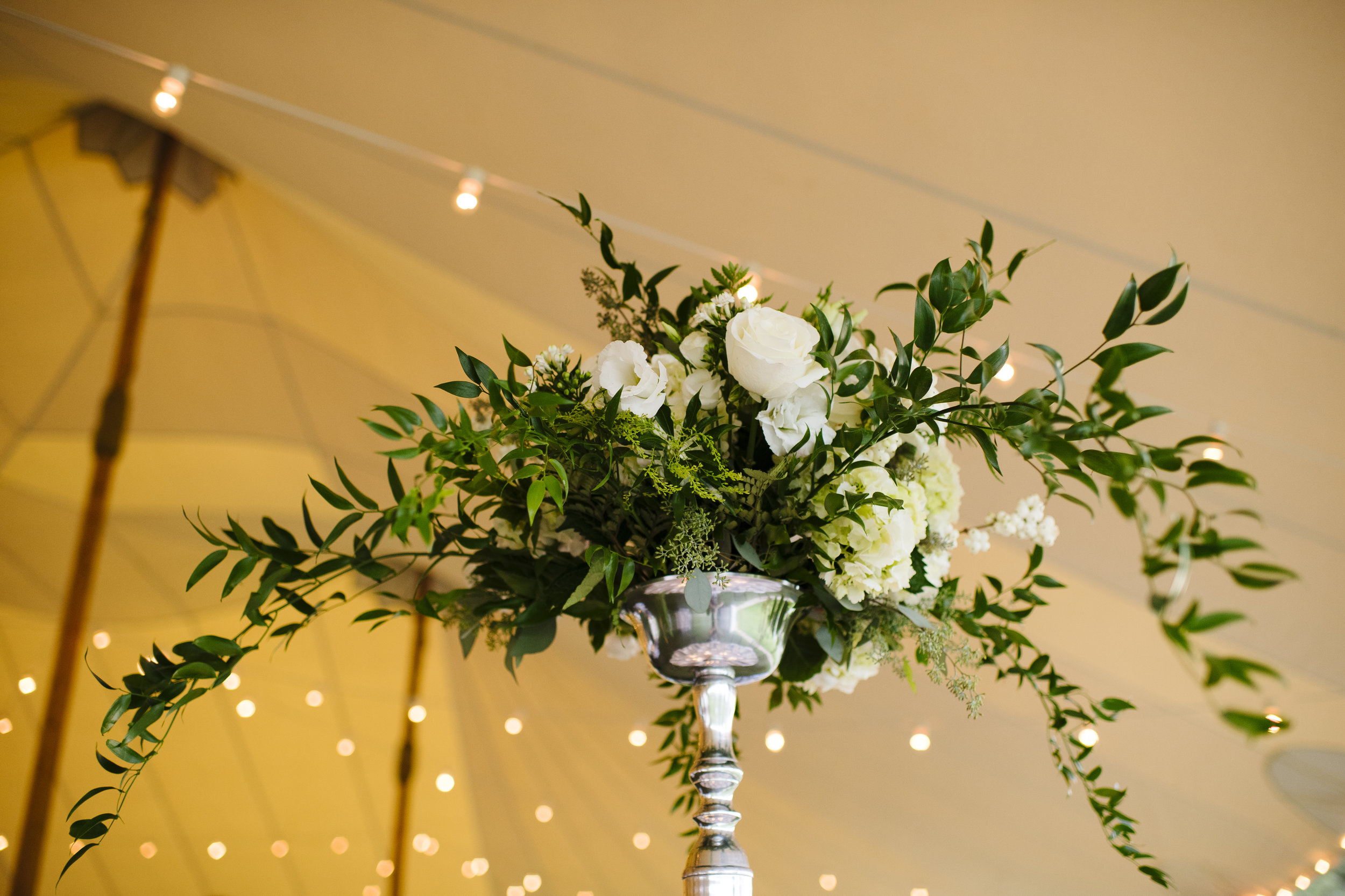 Tall white rose and greenery elegant but classy centerpieces under tent at Jonathan Edwards Winery in Connecticut - Pearl Weddings &amp; Event
