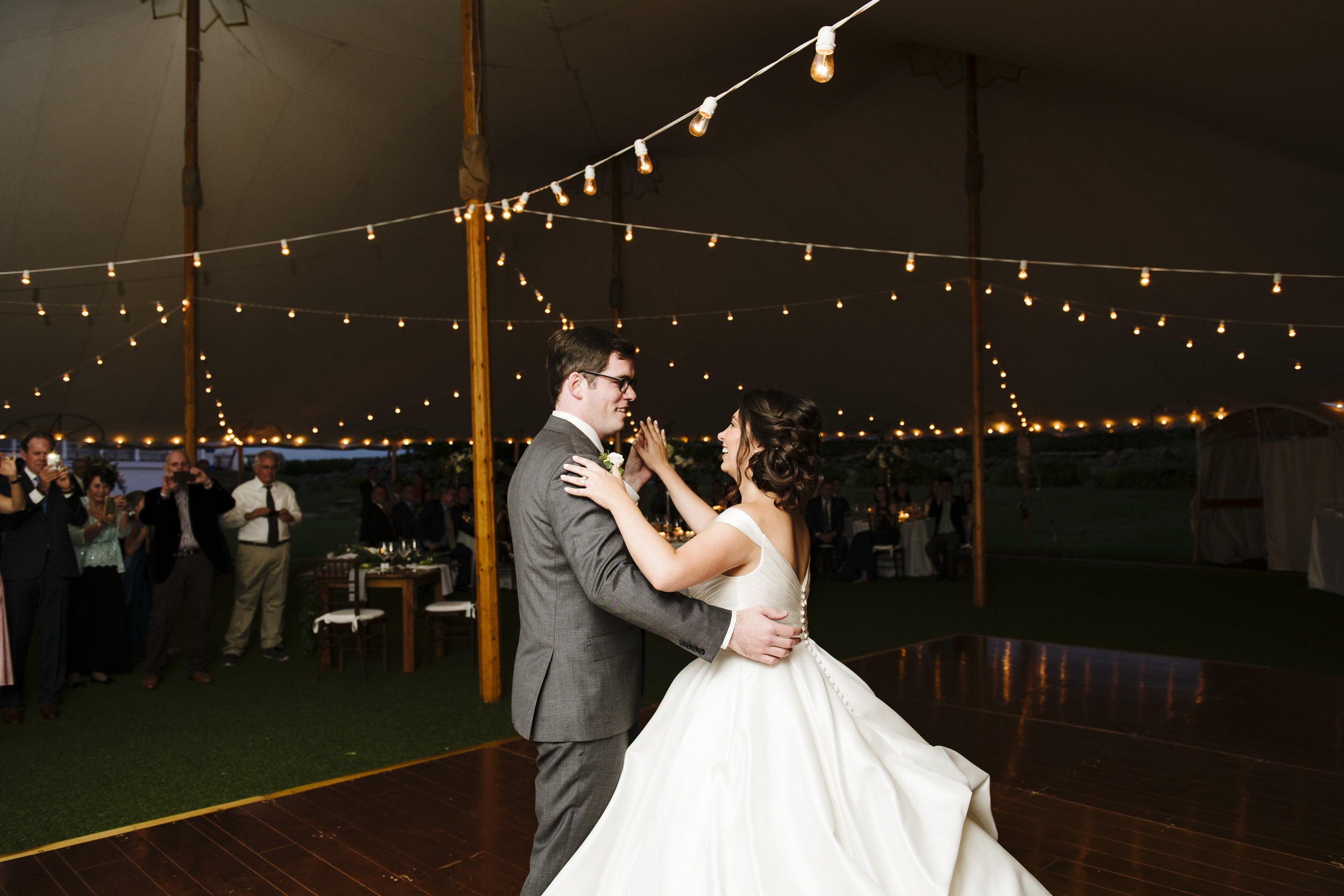 First dance on dance floor under a tent with cafe strung lighting at Jonathan Edwards Winery in Connecticut - Pearl Weddings &amp; Events