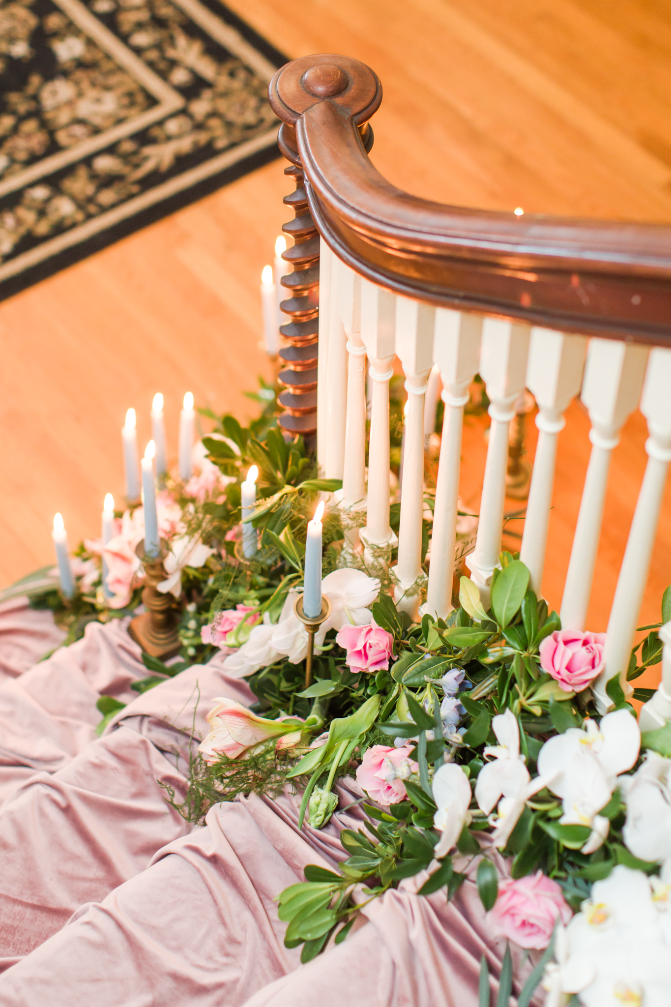 Pink velvet covered staircase with white orchids, pink florals, greenery and light blue candles in gold holders - Pearl Weddings &amp; Events 