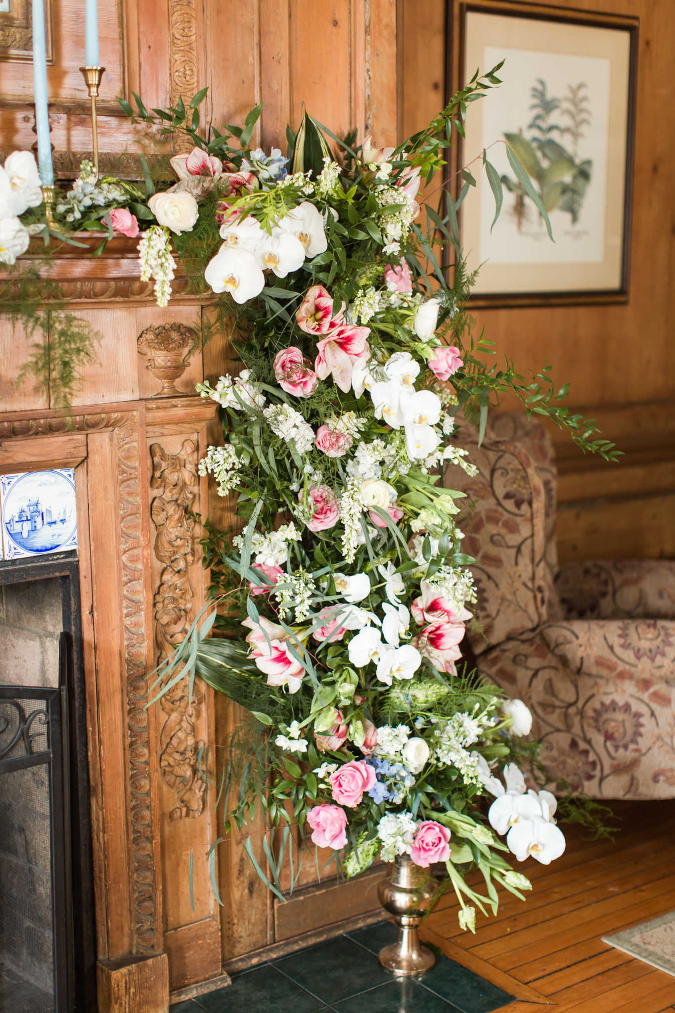 Lush greens, pinks and white orchids arching up a candle light fire place for an intimate ceremony at the Haley Mansion in Mystic Connecticut - Pearl Weddings &amp; Events