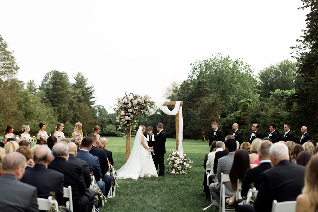 Ceremony Arch with blush and white florals and white draping fabric - Pearl Weddings and Events