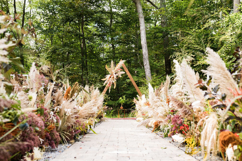 Boho ceremony with lush dried florals and triangle ceremony arch - Pearl Weddings &amp; Events