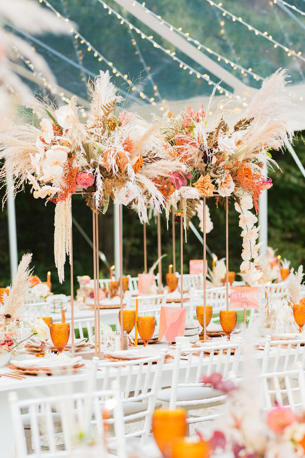 Tall dried flower centerpieces on white farm tables for a boho wedding - Pearl Weddings &amp; Events