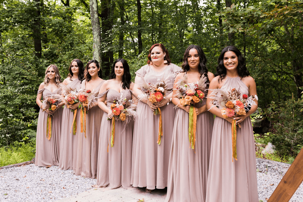 The bridesmaids line up in matching dresses as they hold their bouquets