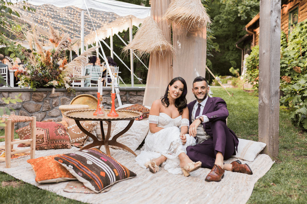 Couple relaxing in a boho lounge area during their wedding