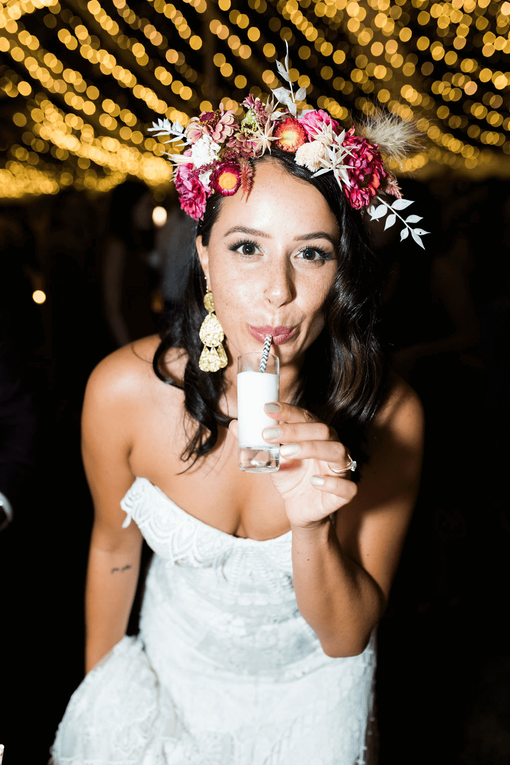 Bride looks at camera while sipping from a shot glass