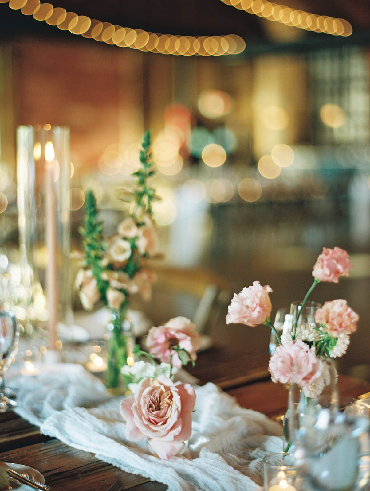 A close up of a table setup with flowers, linens, and candles