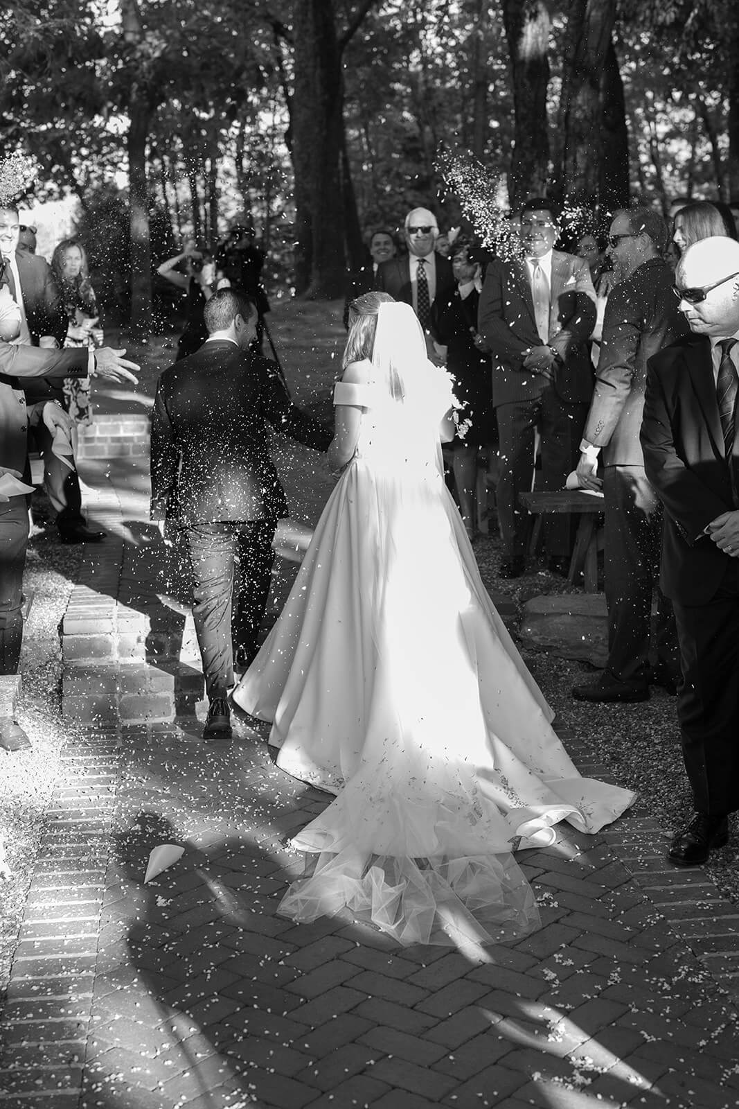 Bride and groom hold hands as the walk down the isle after exchanging their vows