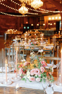 Several tables set up with flowers and candles for the wedding reception