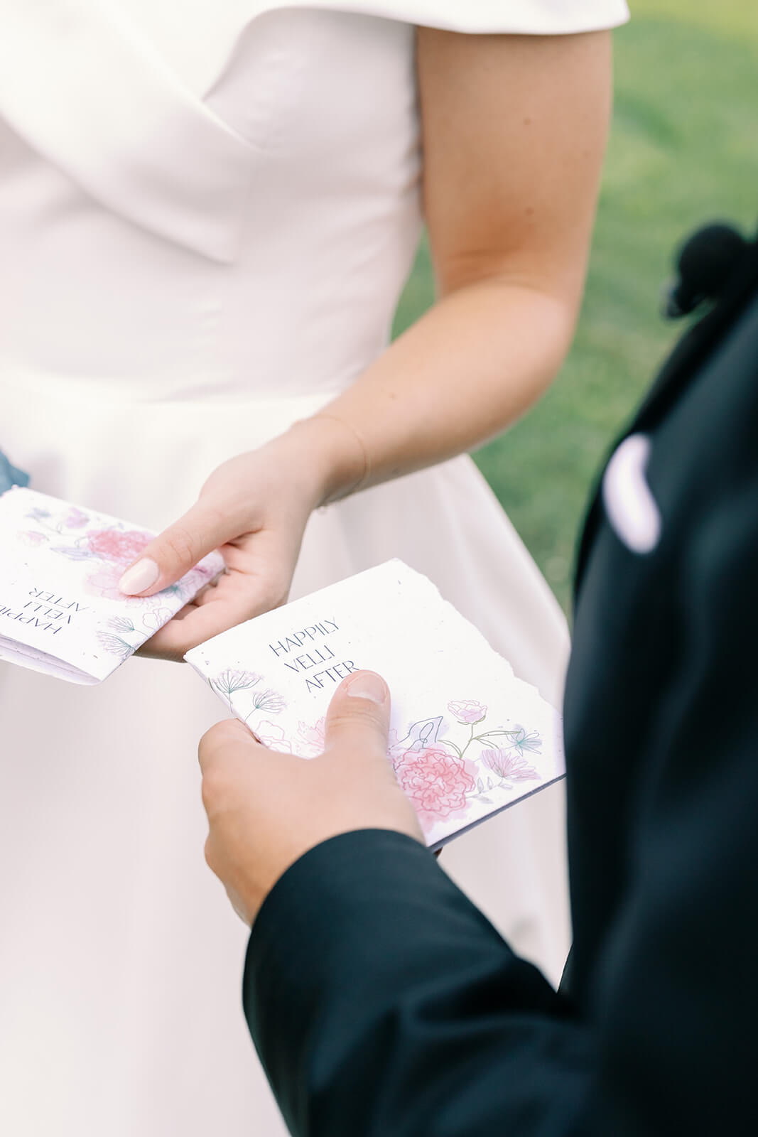 Bride and groom hold cards that read "Happy Velli After"