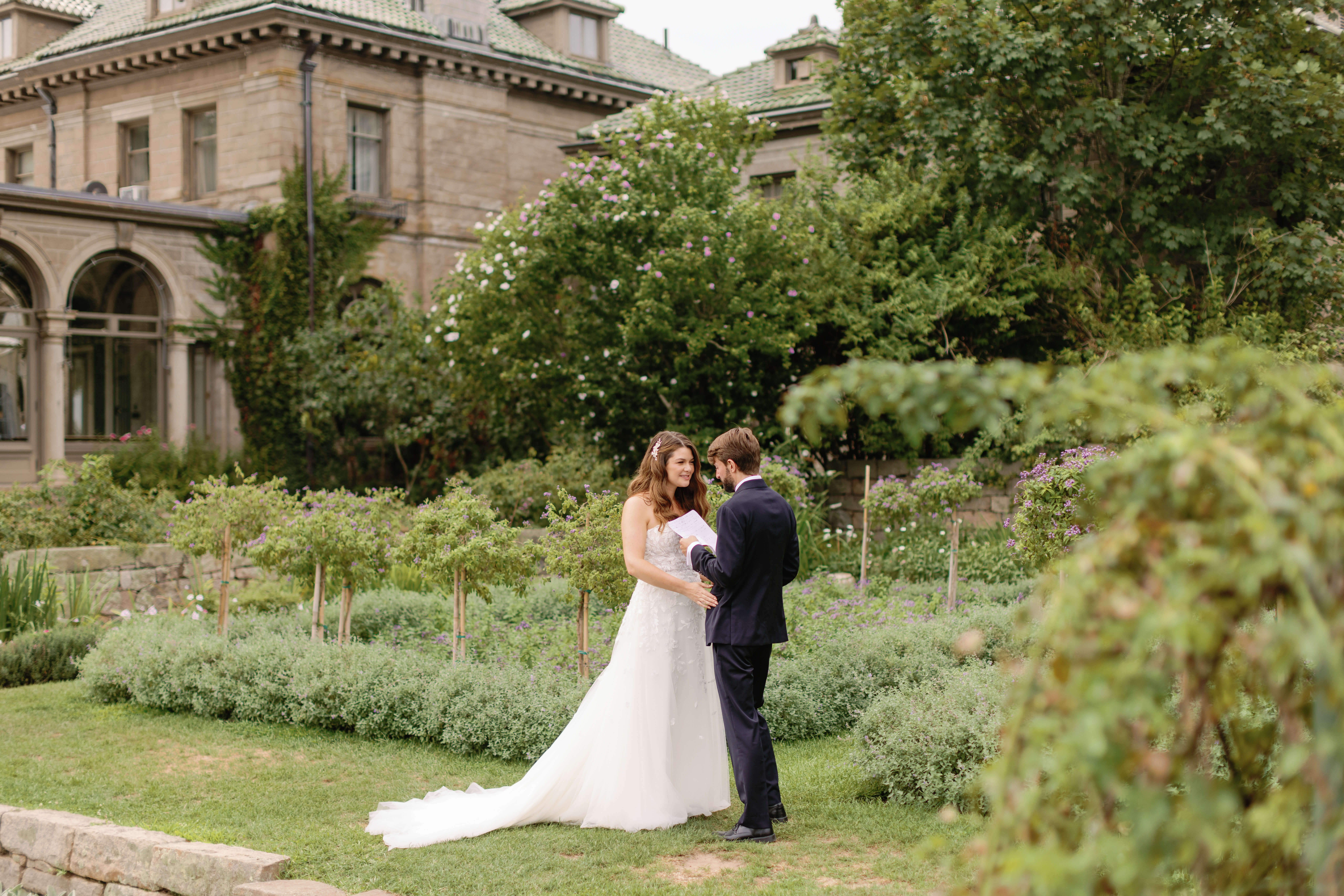 Bride and groom in front of historic mansion for their New England wedding