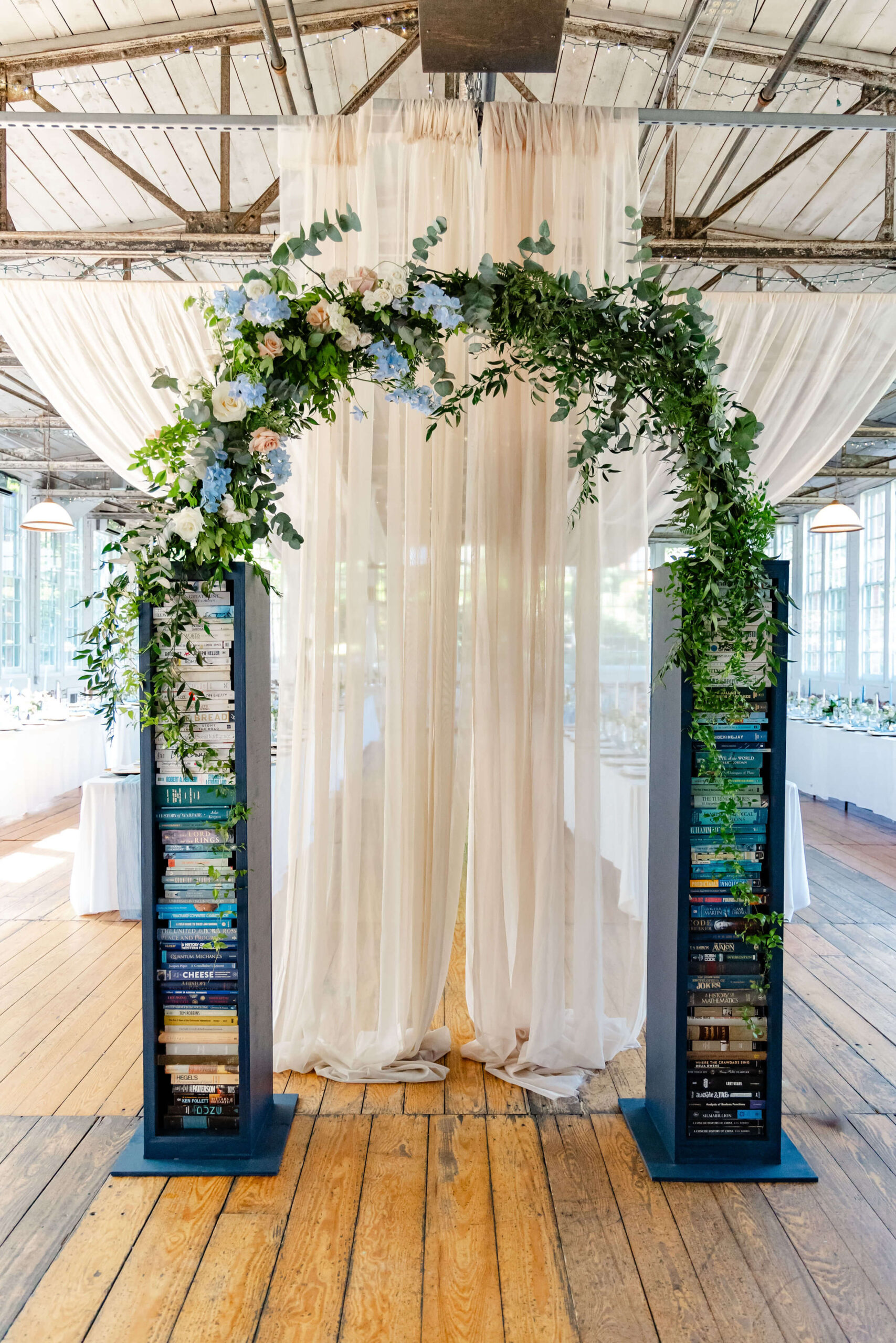 Custom built arch for Sam+Sam's New England wedding with books and flowers.